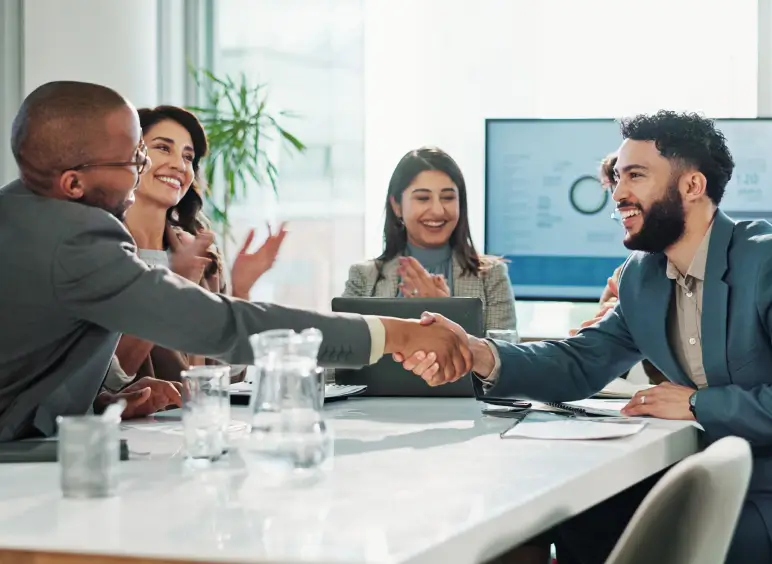 People shaking hands in a meeting room.